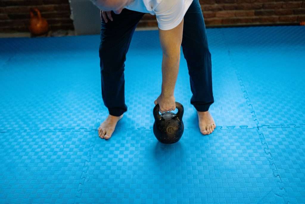 Person performing a kettlebell deadlift to build functional strength and support longevity fitness.