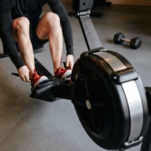 An older adult exercising on an indoor rowing machine as part of a consistent fitness routine.